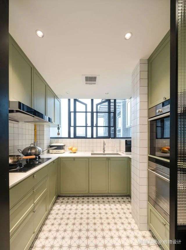 中廚地面鋪貼花磚，搭配綠色櫃門和小白磚牆面，整體顯得清新幹淨