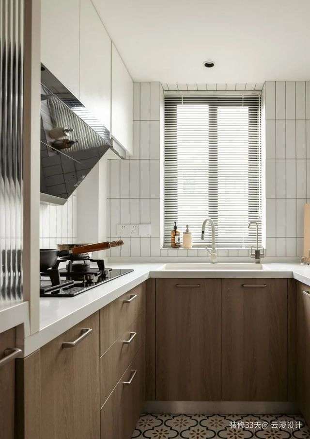 廚房改造後實現U型佈局，白+木的櫥櫃配色搭配地鐵磚牆面，顯得簡約清爽