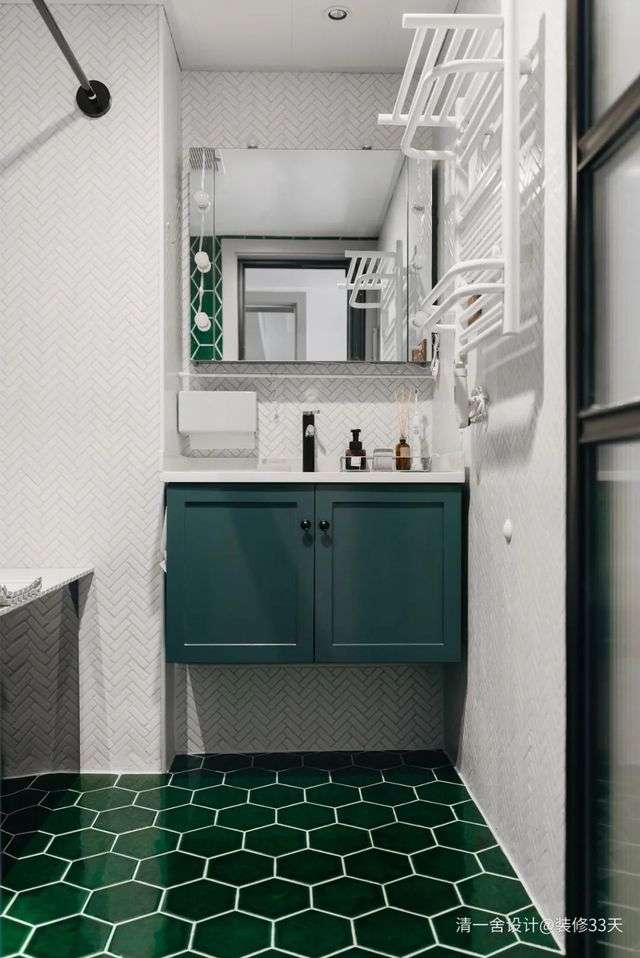 洗手間，墨綠色手工磚表面特別透亮，與黑色浴缸結合之後，有一種浴缸隱形的視覺體驗