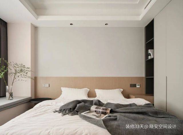 主臥，牆面選擇柔和的牆布與木飾面結合，利用櫃體的格局定製化床頭櫃，提高空間使用效率