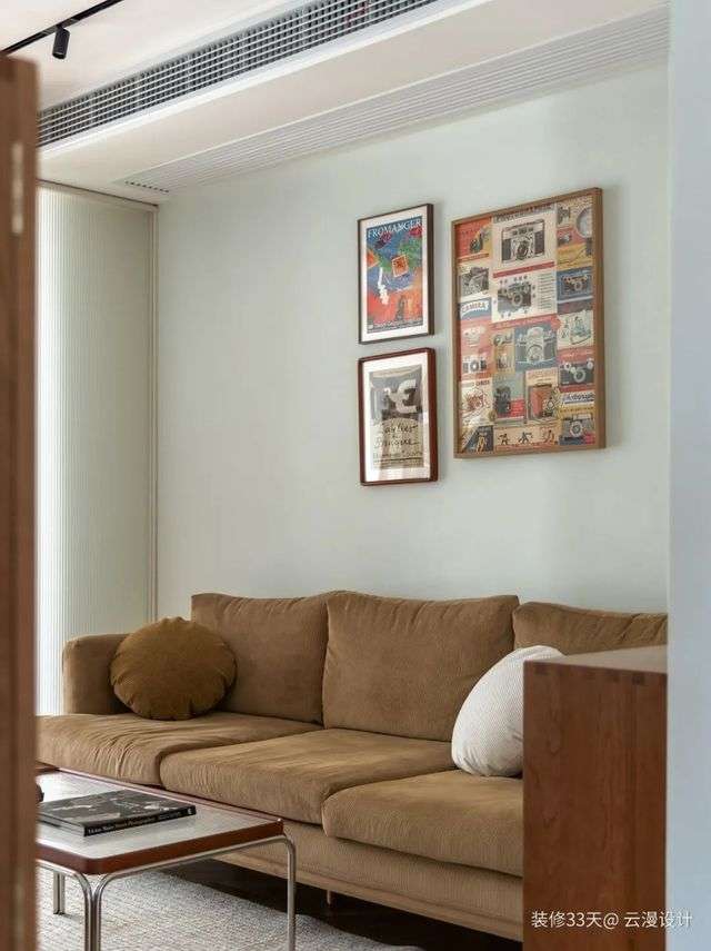 淺咖色沙發搭配復古茶几，淺綠色背景點綴潮流裝飾畫，藝術與生活在此體現